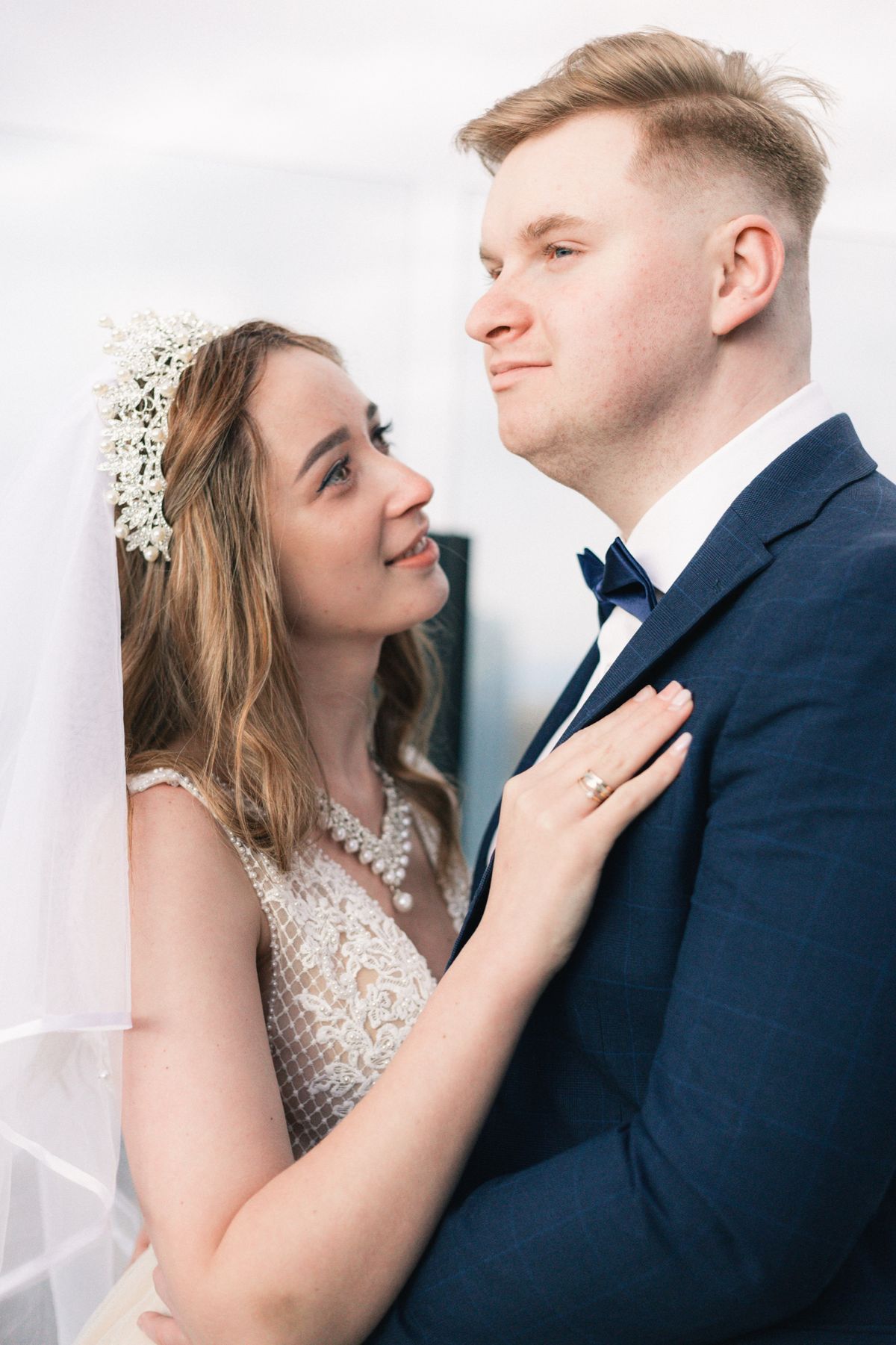 A bride looking up at the groom, her hand on his chest